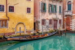 Gondola moored on the dock in a canal in Venice during the lunch break